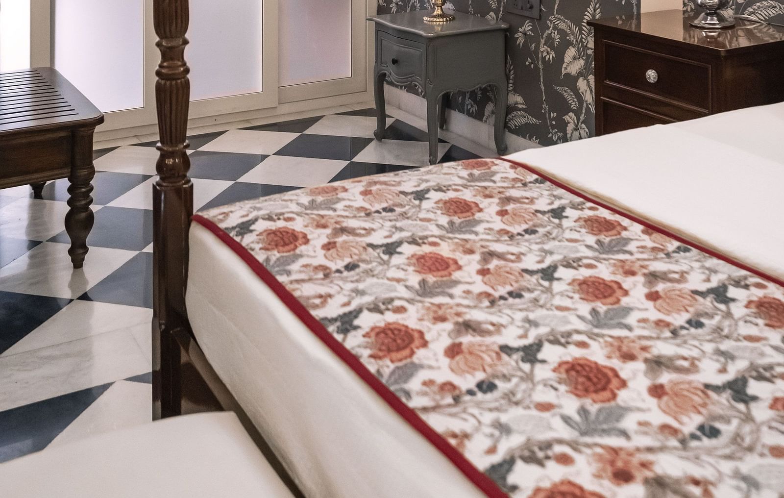 A view of a room at Dileep Kothi, Jaipur with a double bed and a side table with night lamp